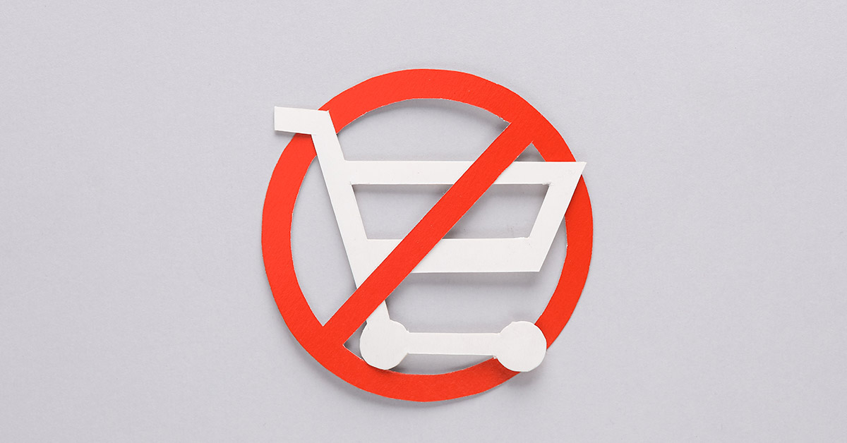 Paper cut shopping cart with prohibition sign on gray background