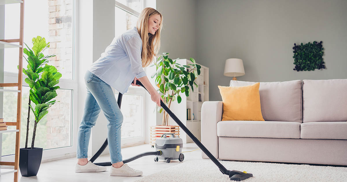 woman in sitting room cleaning house