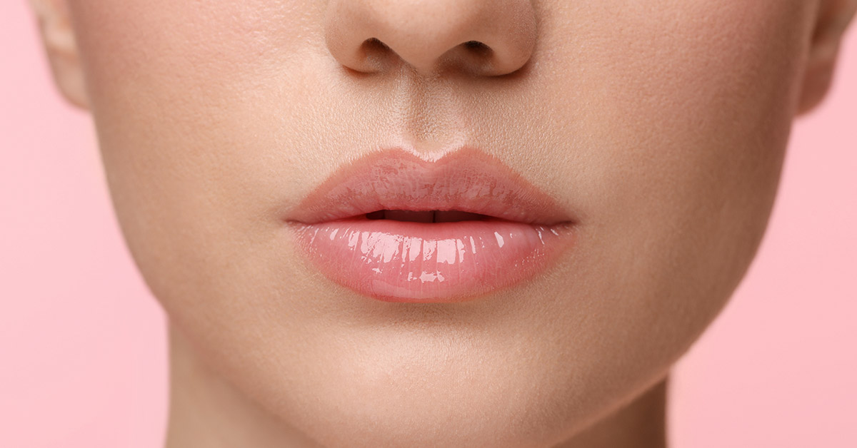 close up of woman's lips with pink background