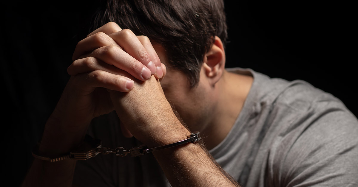 father with hands clasped together over forehead