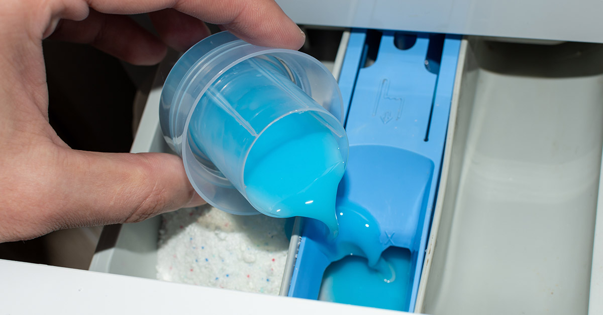 laundry detergent being poured into machine