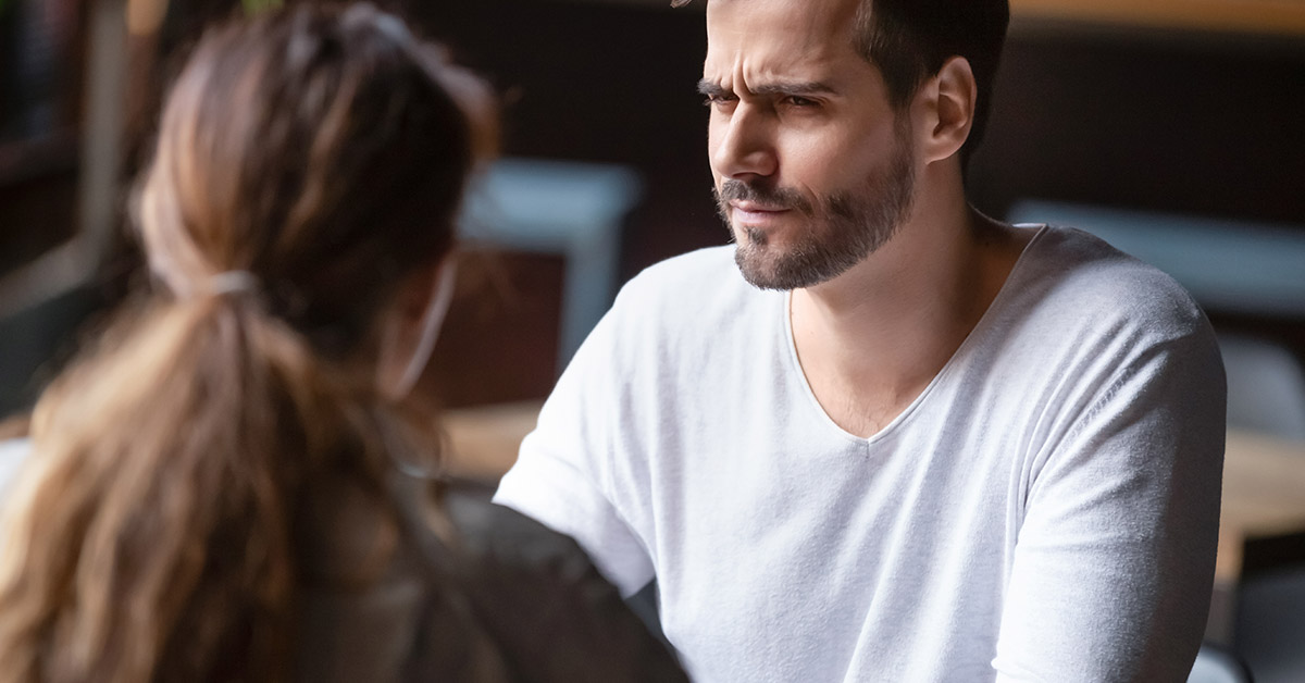 man skeptical on a date looking at woman eyebrow raised