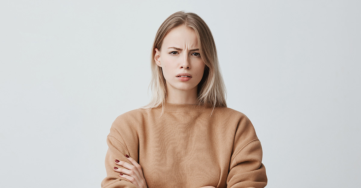woman wearing beige sweater staring