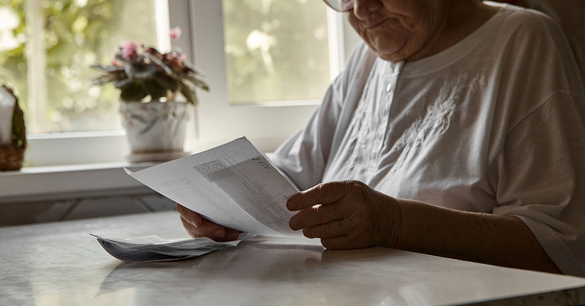 elderly woman examining a piece of paper