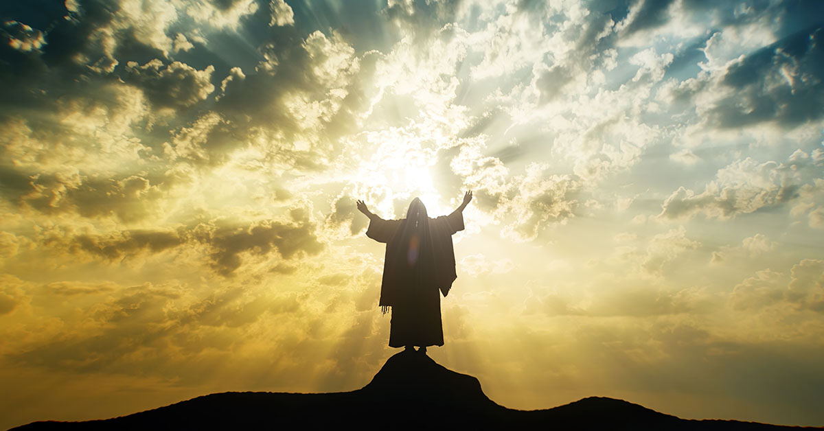 Jesus reaching for the sky as the sun rises behind