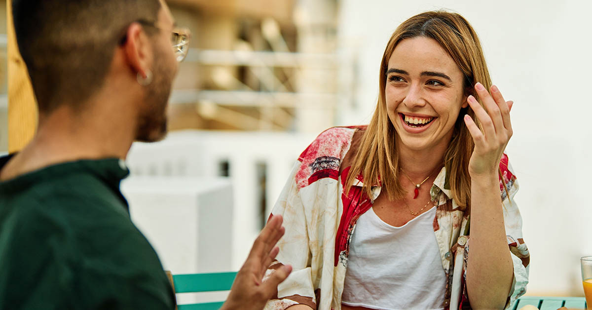 man and woman smiling and laughing with each other. Flirting, first date concept