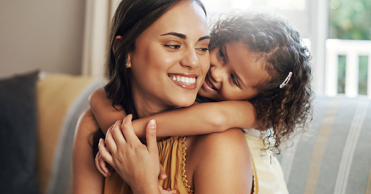 mother with daughter embracing from behind her
