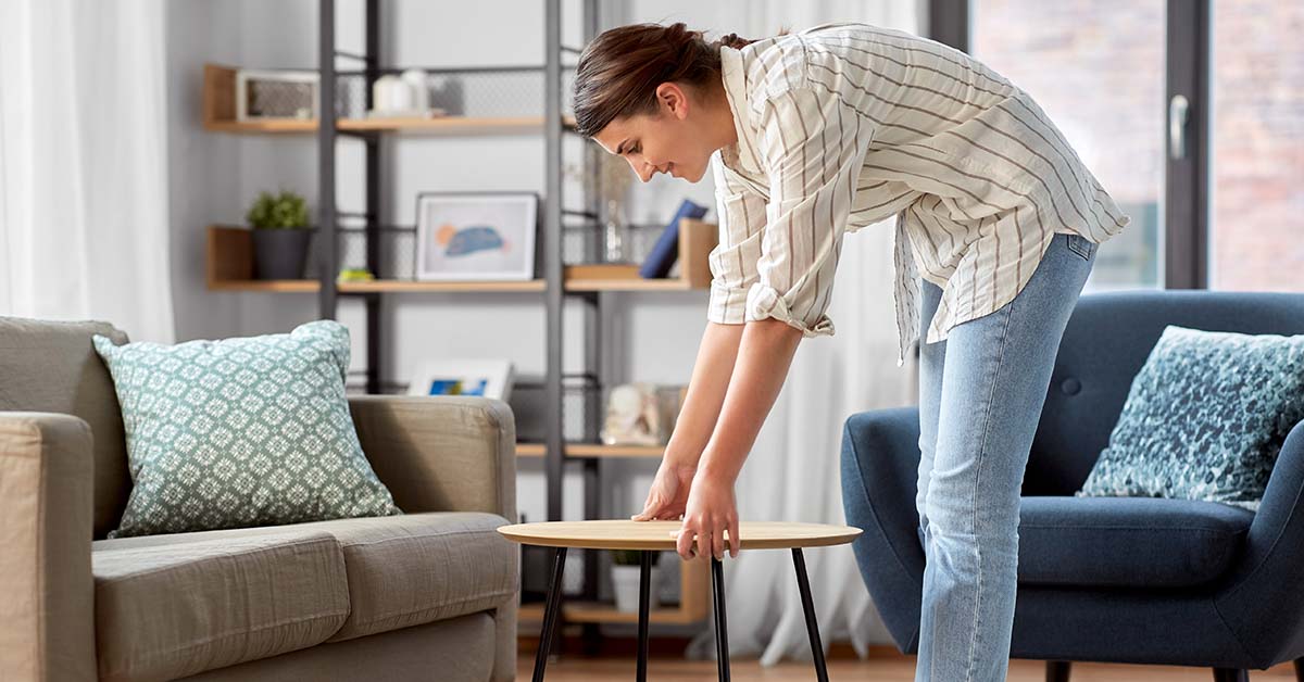 woman arranging furniture in her living room