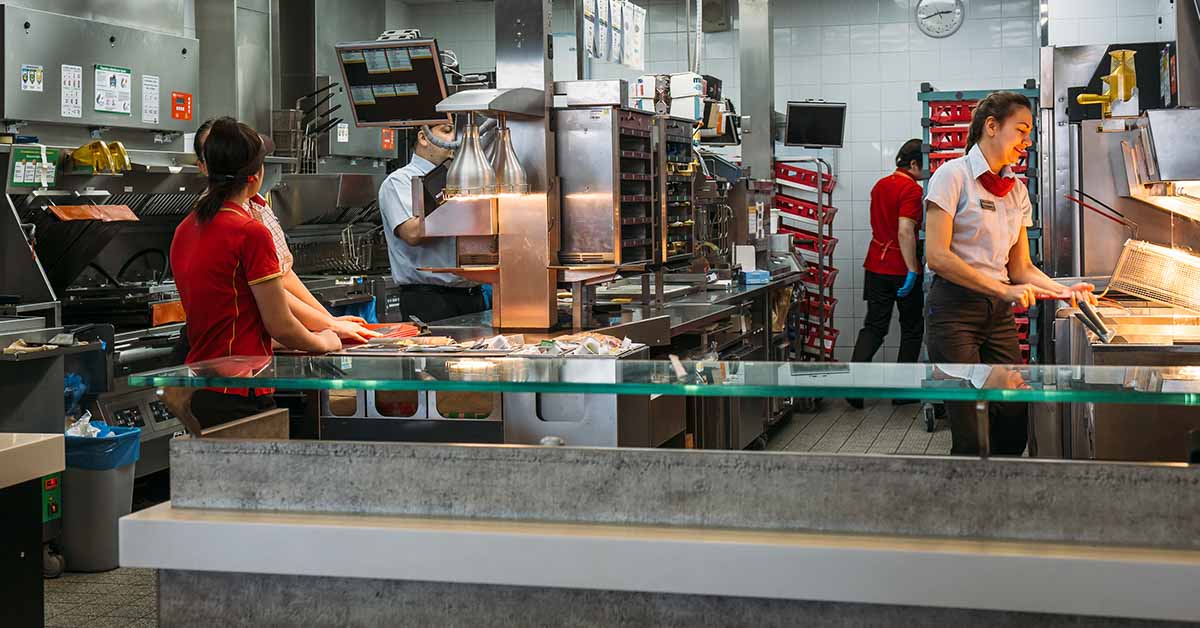Mcdonalds kitchen area with workers, famous fast food cafe or restaurant