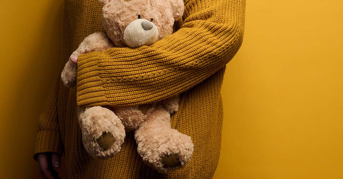 young child holding a stuffed bear