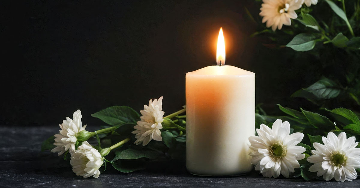lit white candle and daisies. Mourning, tragic loss concept