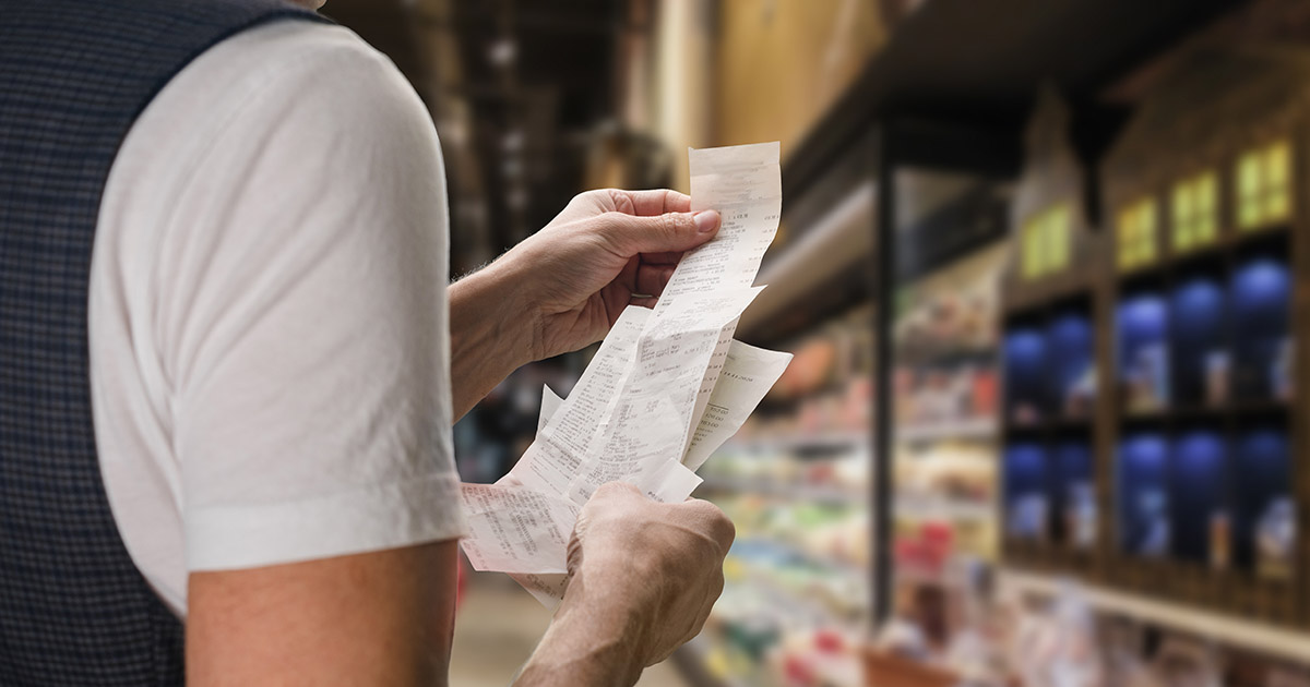person checking receipt at grocery store. Increasing food prices concept