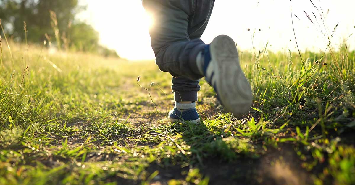 child running through grassy field