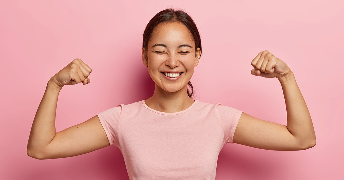 woman flexing arms with pink background. Strong woman, female independence concept