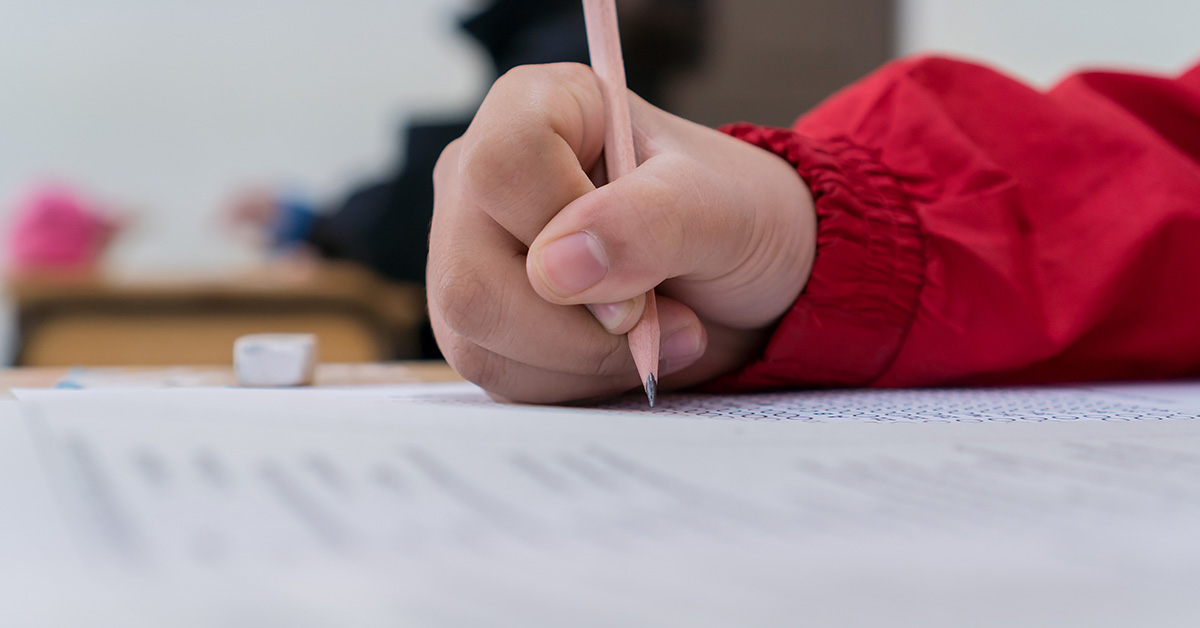 hand writing with a pencil on paper