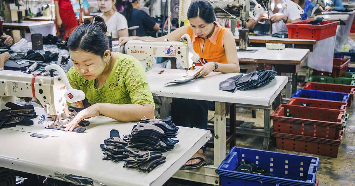 Asian workers sewing in fashion manufacturing setting