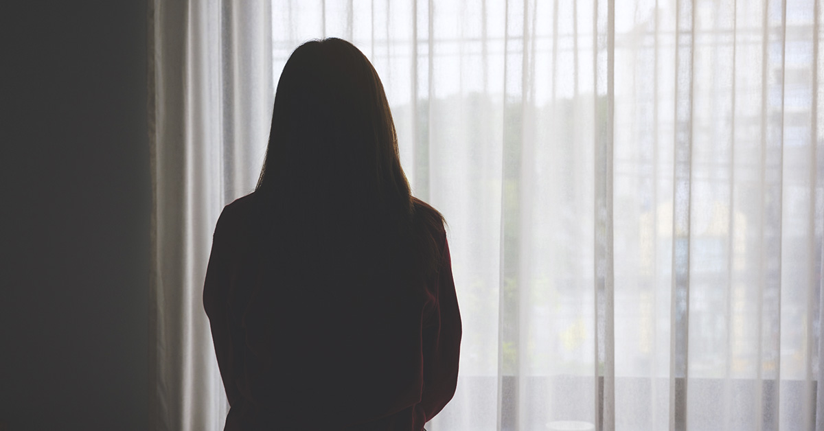 silouhette of woman looking out the window