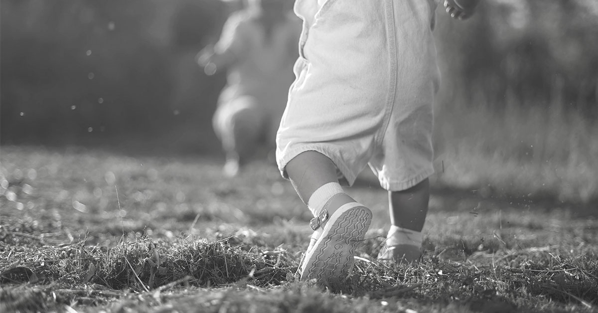 black and white image of baby walking