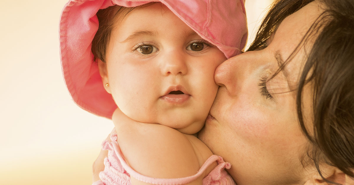 Mother kissing their child on the cheek