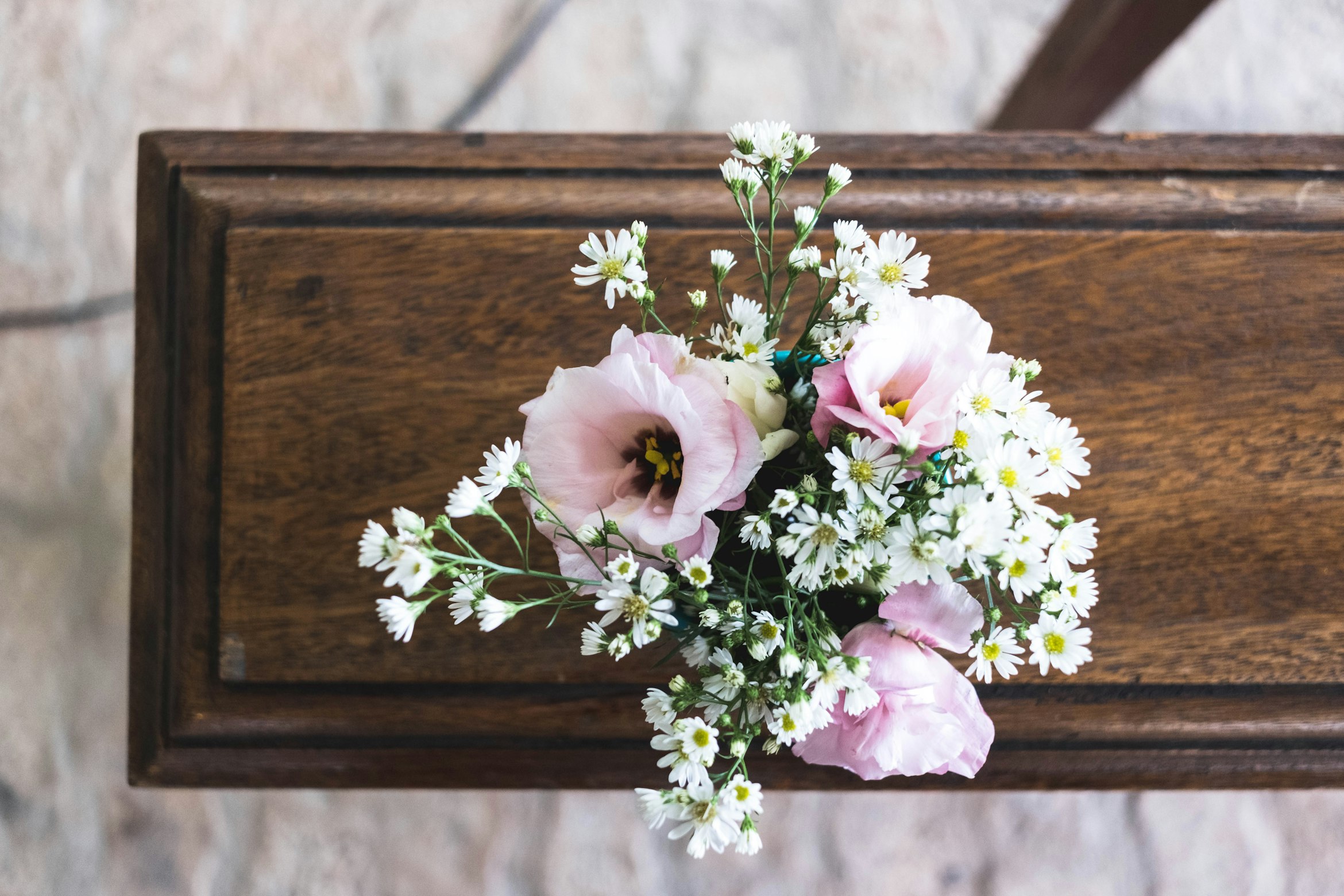 pink flowers on wooden table at funeral