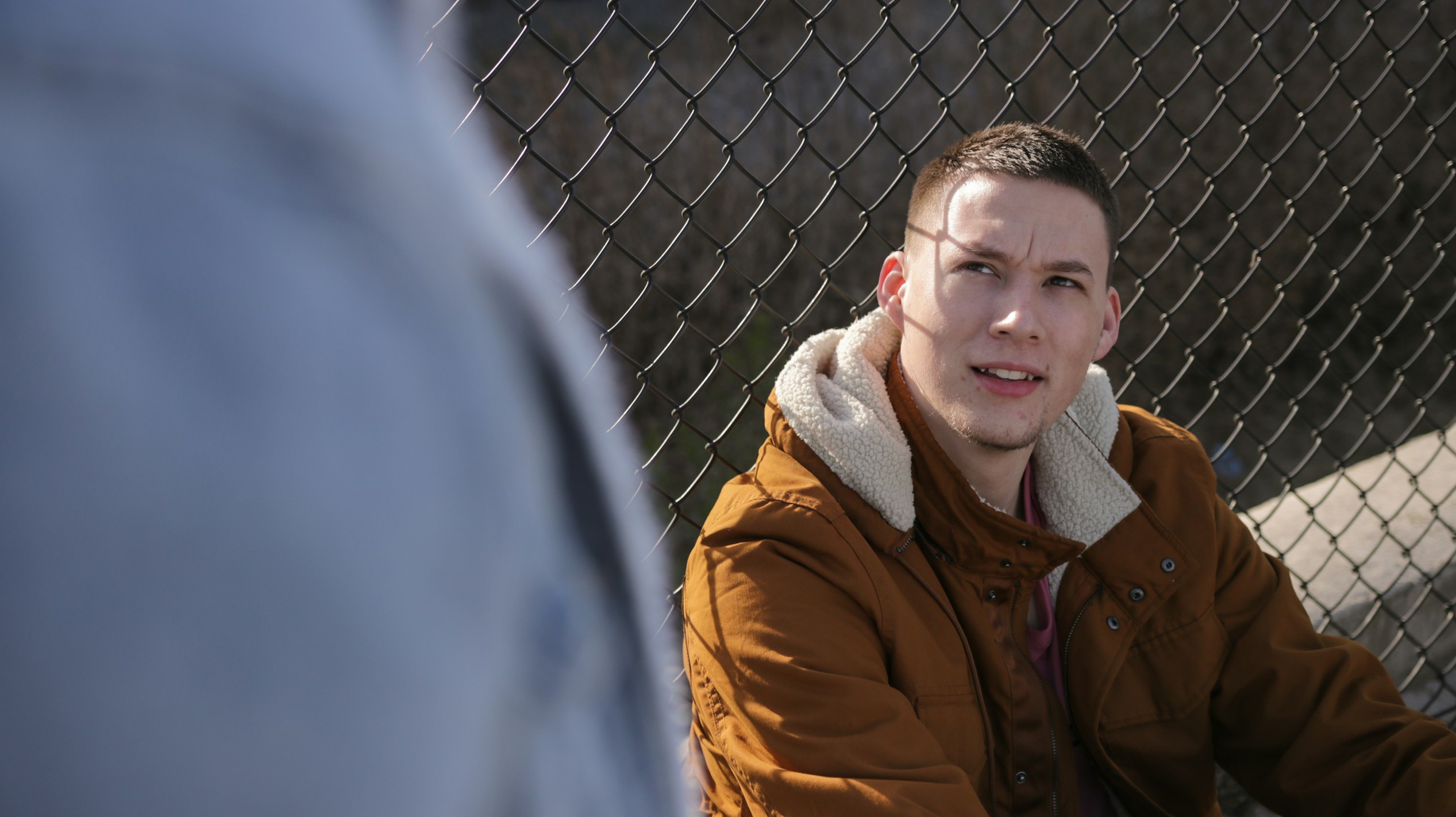 man sitting near fence
