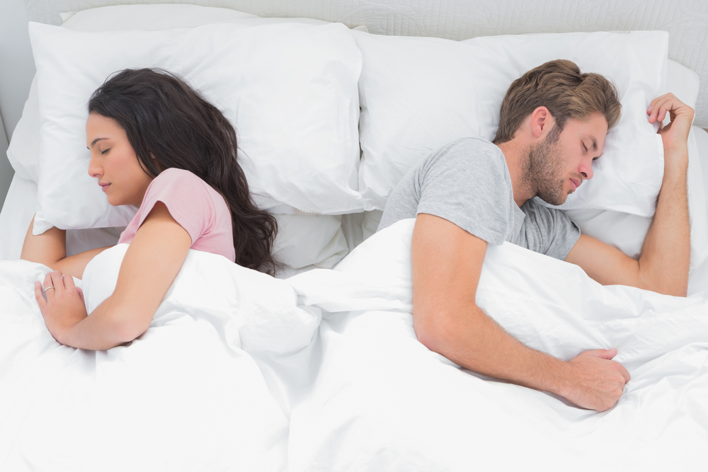 Beautiful couple sleeping back to back in their bed