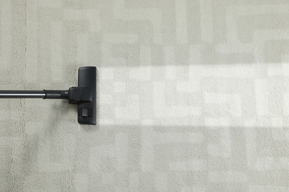 Hoovering carpet with vacuum cleaner, top view and space for text. Clean trace on dirty surface