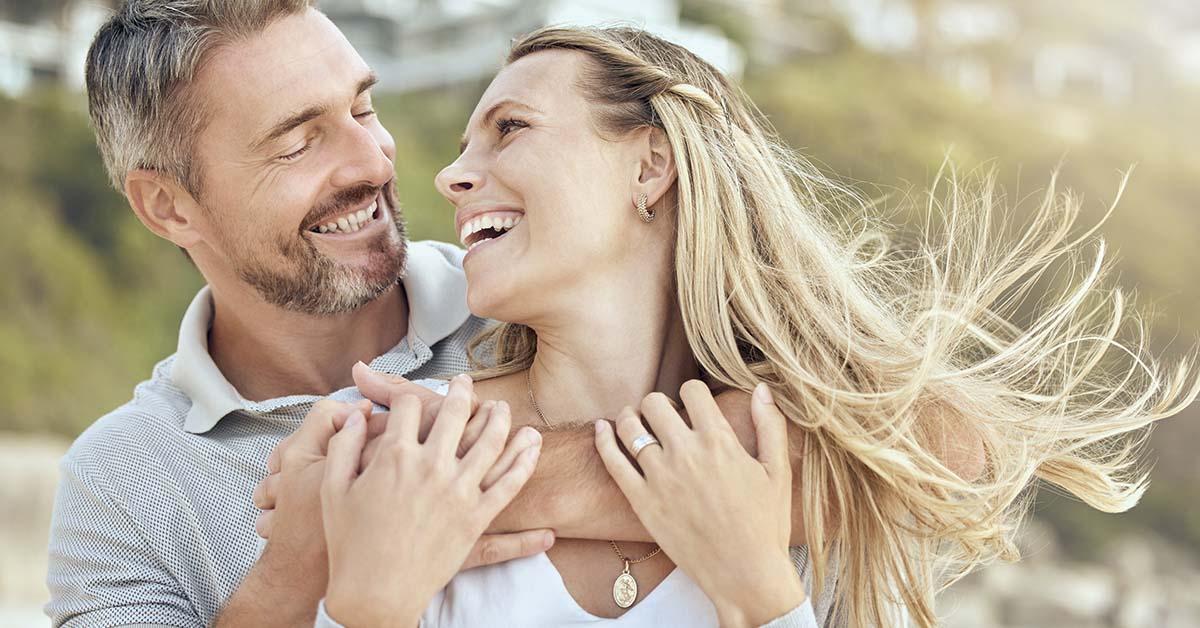 middle aged couple embracing, smiling, looking at each other in the eyes
