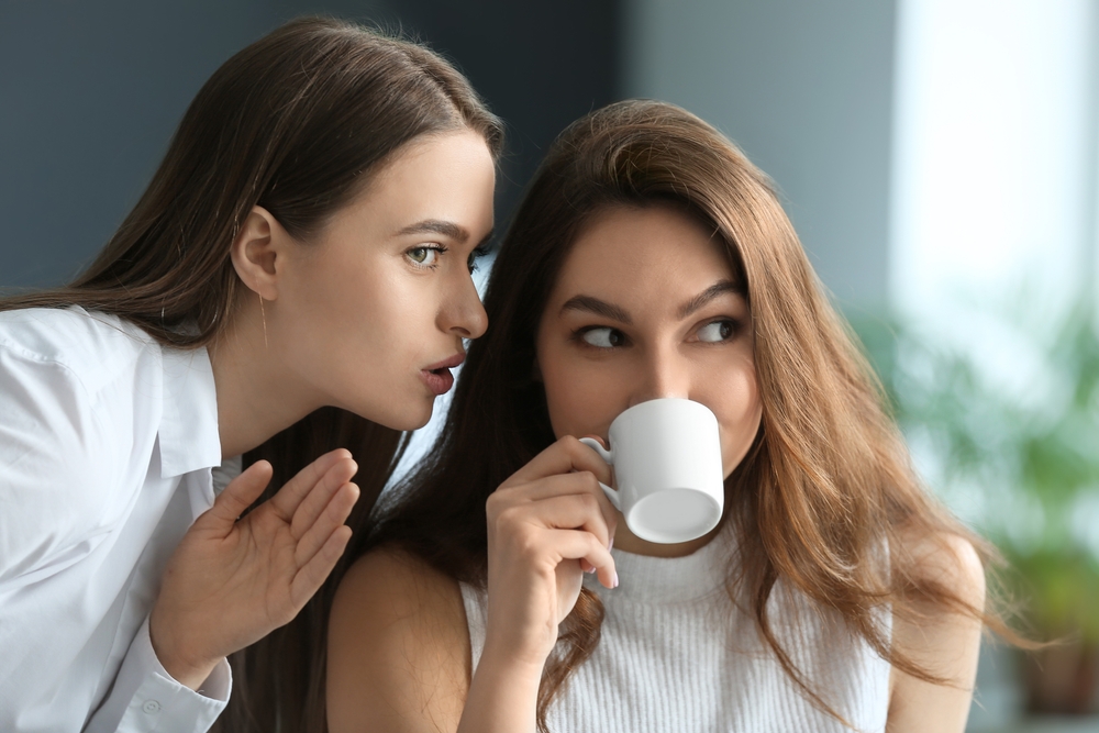 Female colleagues gossiping in office