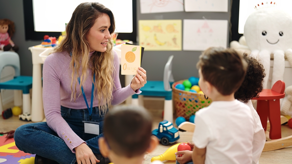 Woman and boys having vocabulary lesson with word cards at kindergarten